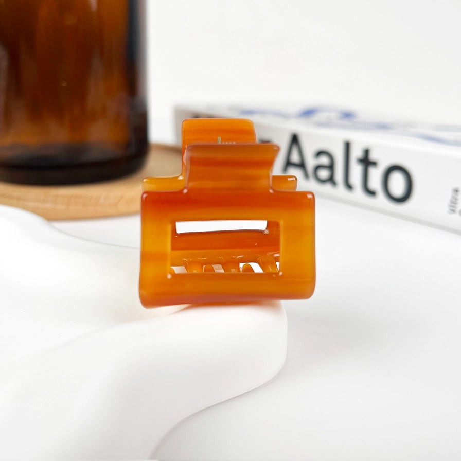 Hårklemme Mini Square i recycled plast – bæredygtig, elegant og skånsom mod håret. Fås i smukke farver med marmormønster og blank finish.