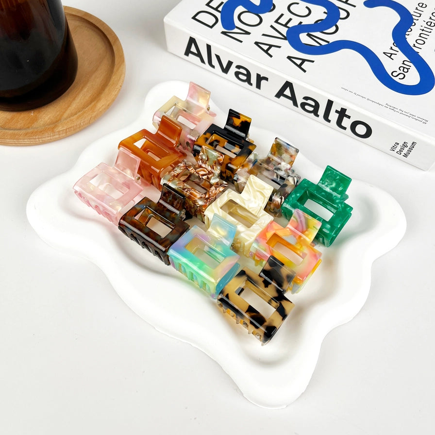 Hårklemme Mini Square i recycled plast – bæredygtig, elegant og skånsom mod håret. Fås i smukke farver med marmormønster og blank finish.