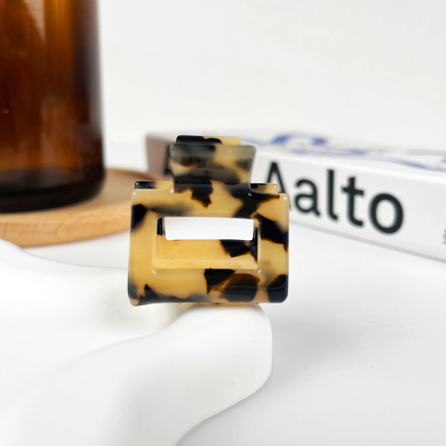 Hårklemme Mini Square i recycled plast – bæredygtig, elegant og skånsom mod håret. Fås i smukke farver med marmormønster og blank finish.