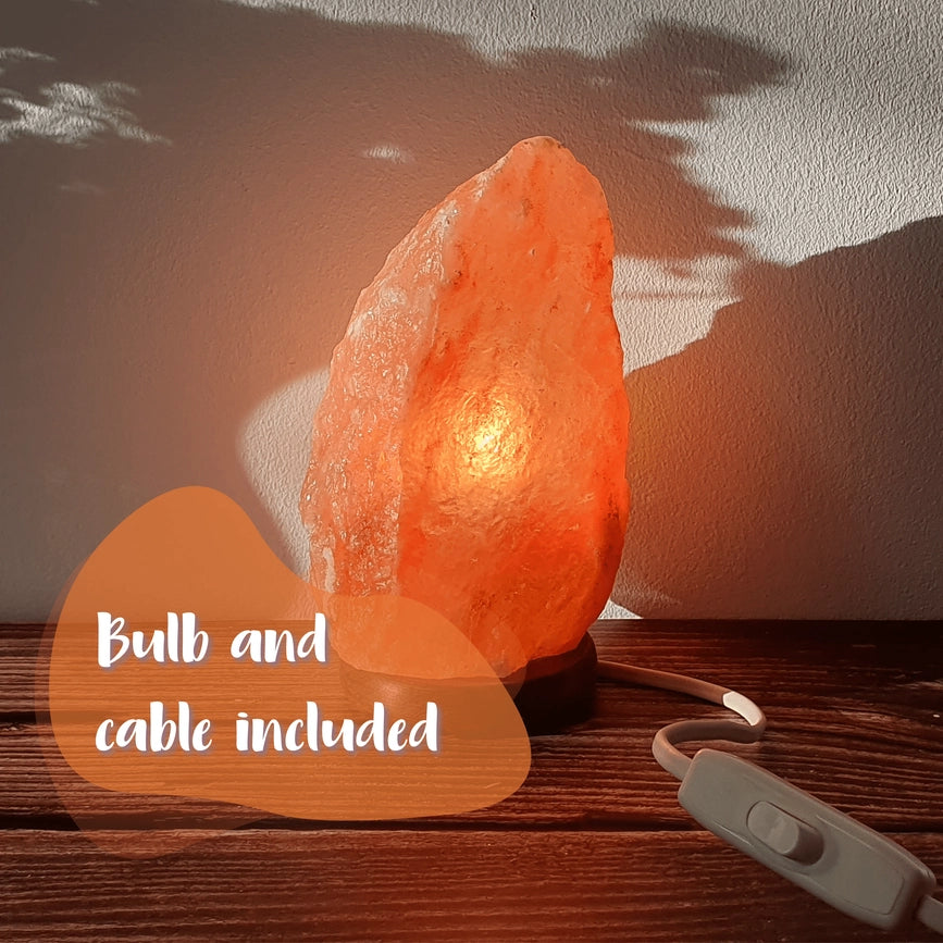 En smuk, håndskåret pink Himalaya saltlampe, der spreder en varm, rolig og naturlig glød i dit hjem.