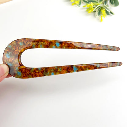 Fransk hårnål i bæredygtig bioplast. Elegant U-formet design, der holder håret naturligt og sikkert på plads – stilfuld og skånsom håropsætning.