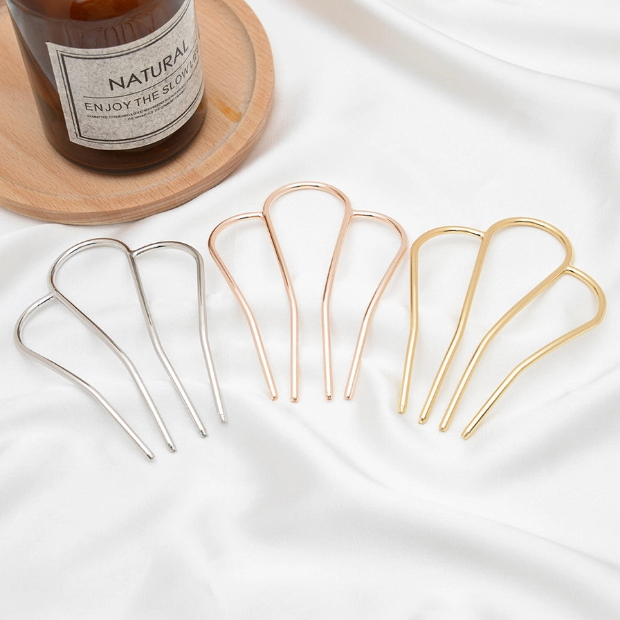 Fransk hårnål i metal med M-form – vælg mellem guld og sølv. Elegant, holdbar og perfekt til naturlige og stilfulde håropsætninger.