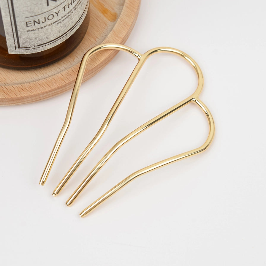 Fransk hårnål i metal med M-form – vælg mellem guld og sølv. Elegant, holdbar og perfekt til naturlige og stilfulde håropsætninger.
